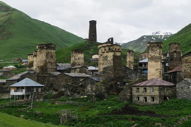 Yeşil yamaçta taş evlerin arasında Uşguli'nin Svan kuleleri